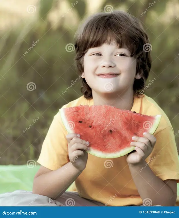 Anak yang bahagia memakan buah-buahan