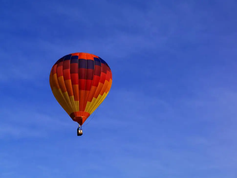 Gambar balon udara di langit, melambangkan ambisi dan mencapai impian.