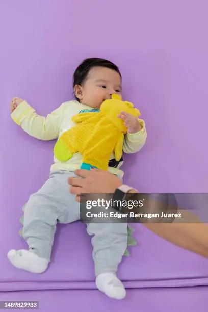 Tangan memberikan boneka kepada seorang anak.