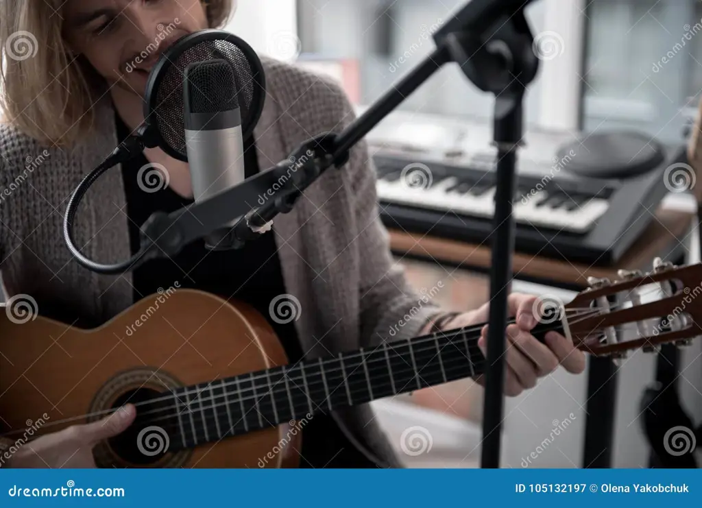 Seorang gitaris sedang memainkan gitar dengan gembira