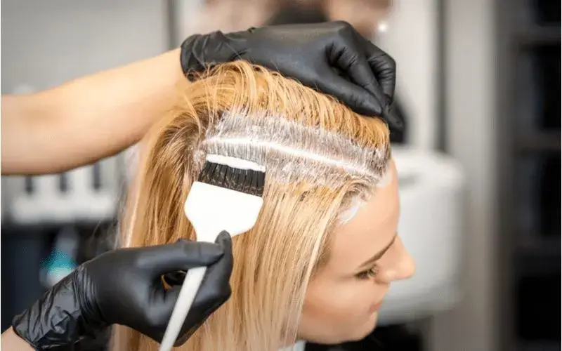 Wanita sedang bleaching rambut di rumah