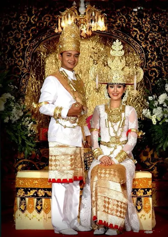 Pasangan pengantin dengan baju adat Lampung