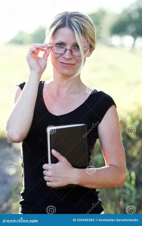 Gadis cantik sedang membaca buku dengan kacamata.