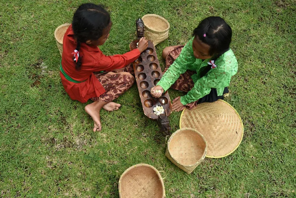 Sekelompok anak-anak bermain berbagai macam permainan tradisional, termasuk sengklek.