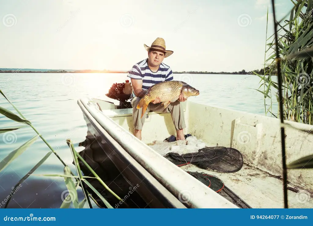 Seorang pemancing yang bahagia memegang ikan besar.