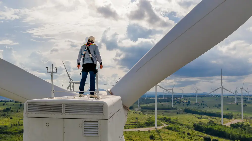 Seorang insinyur energi terbarukan memeriksa turbin angin