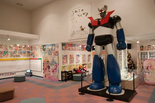 Interior museum anime yang menampilkan berbagai artefak dan pajangan menarik.