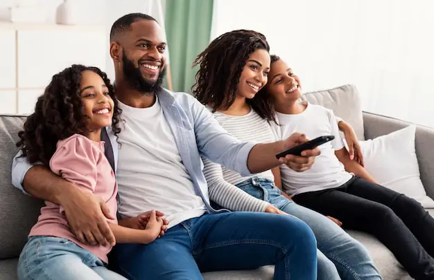 Gambar orang-orang bahagia sedang menonton televisi