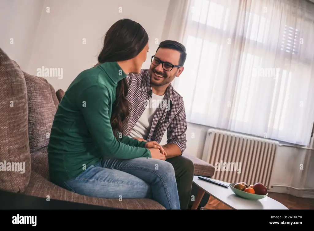 Gambar pasangan yang bahagia bersantai di rumah, menggambarkan keintiman hubungan mereka.