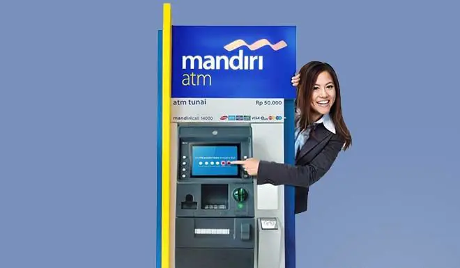 Orang-orang menggunakan ATM Mandiri