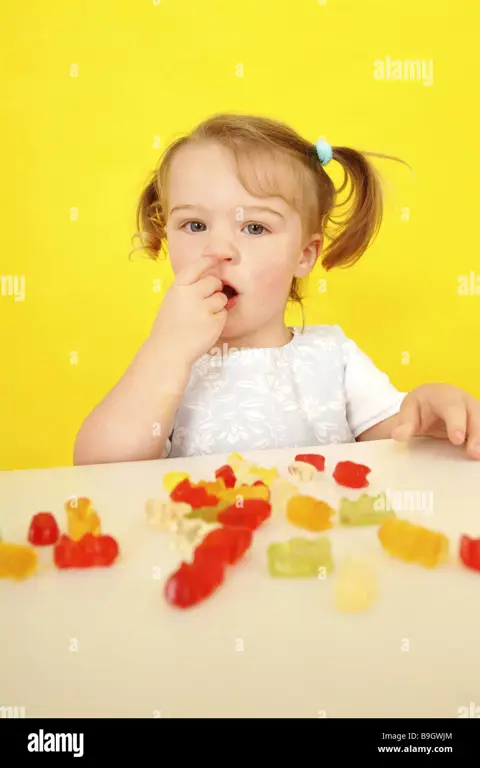 Anak kecil sedang menikmati permen songong.