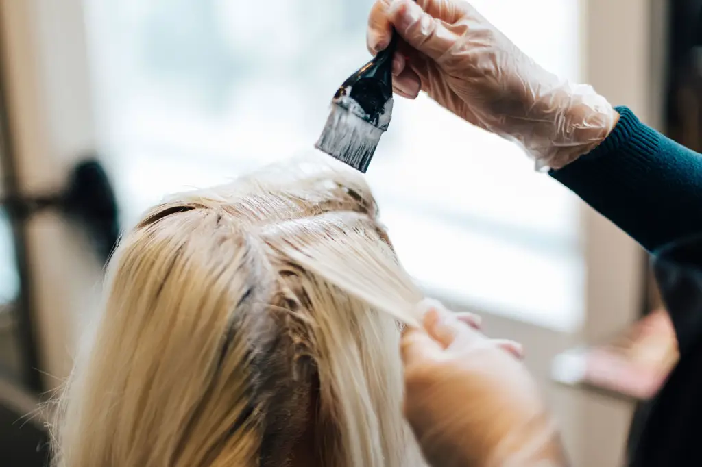 Penata rambut sedang melakukan bleaching