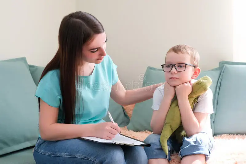 Psikolog anak sedang berbicara dengan anak kecil