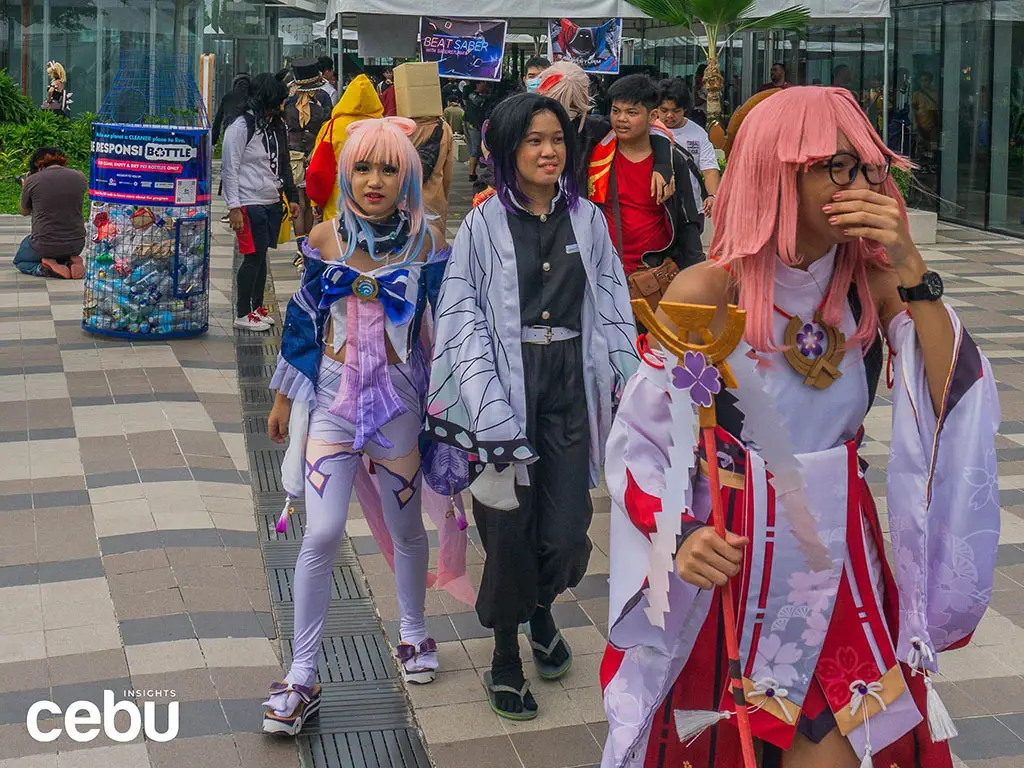 Acara konvensi anime dengan banyak pengunjung yang bercosplay.