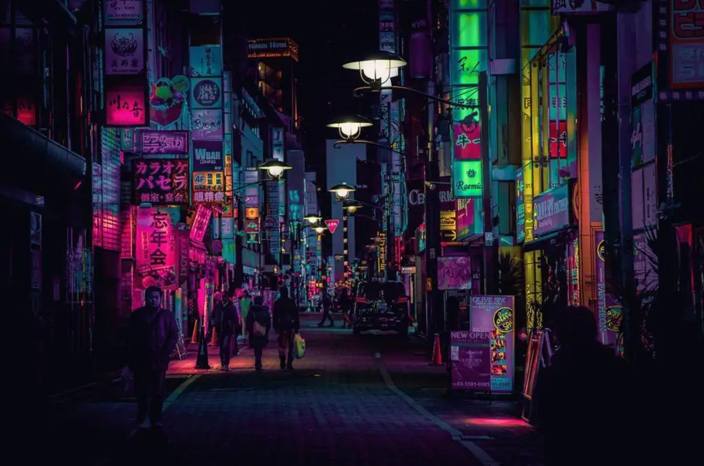 Gambar jalanan Tokyo di malam hari dengan lampu neon yang terang benderang