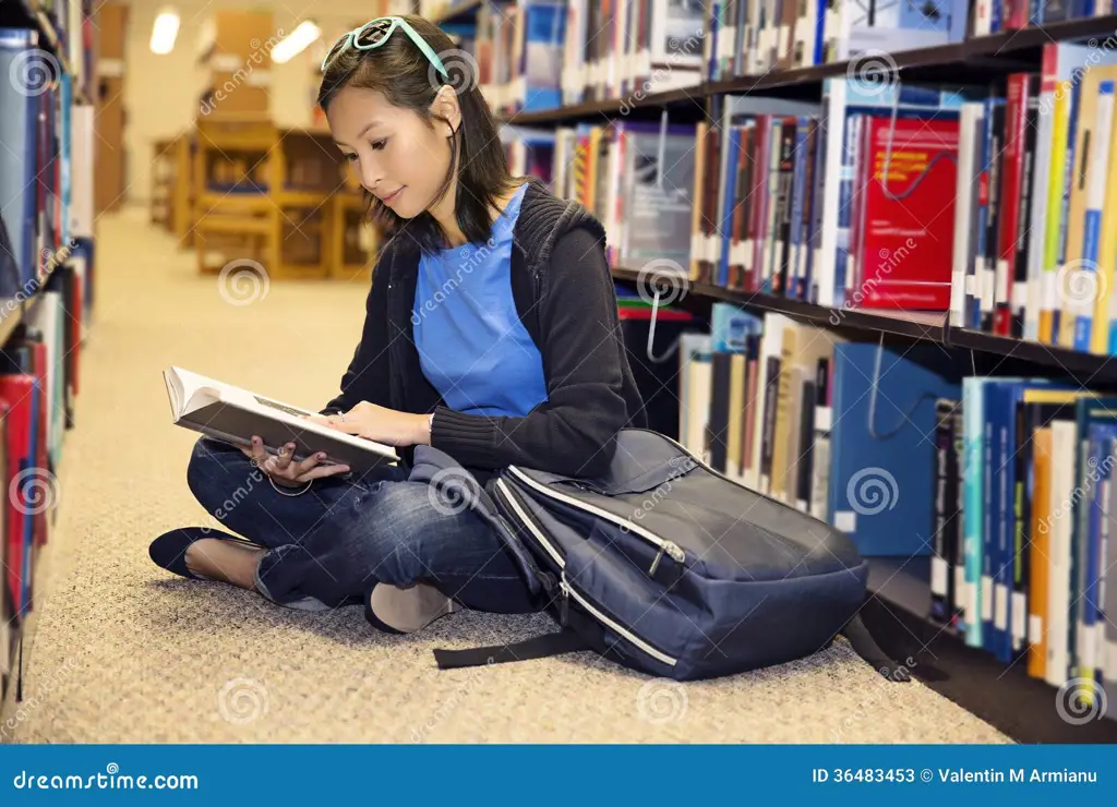 Seseorang membaca buku di perpustakaan