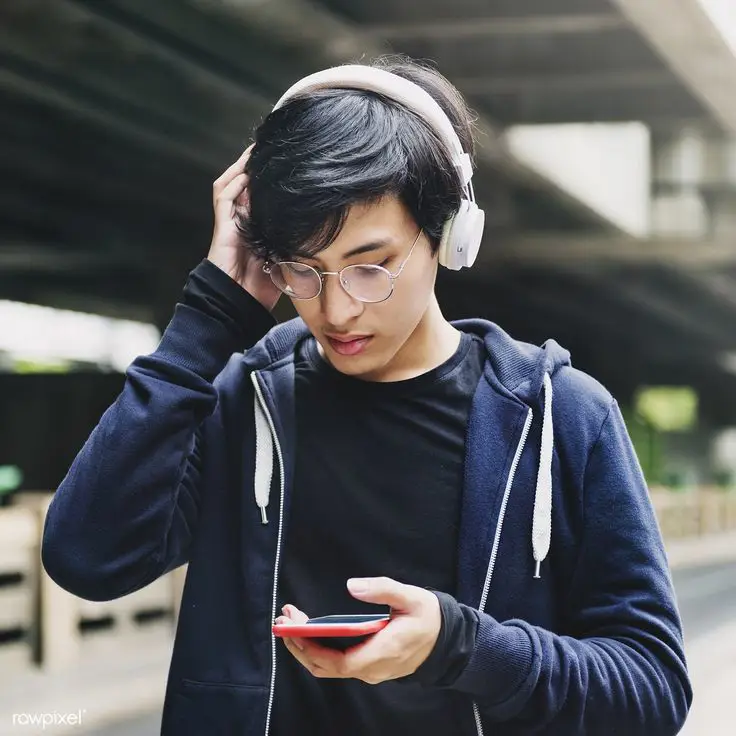 Seseorang sedang mendengarkan musik dengan headphone