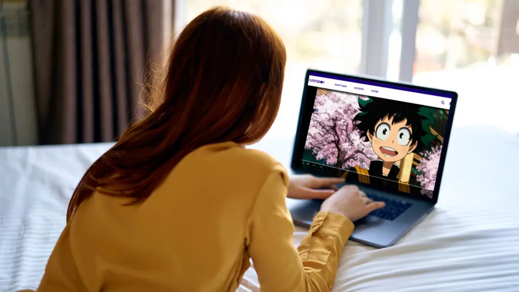 Gambar seseorang menonton anime di laptop dengan ekspresi terkesima.