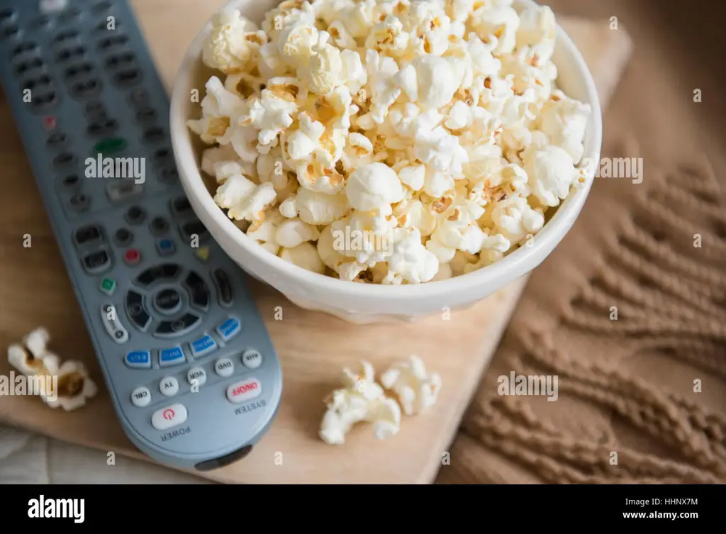 Popcorn dan remote control di depan TV