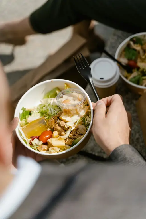 Seseorang sedang menikmati semangkuk besar salad