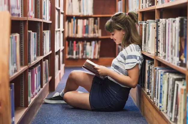 Seseorang membaca buku di perpustakaan