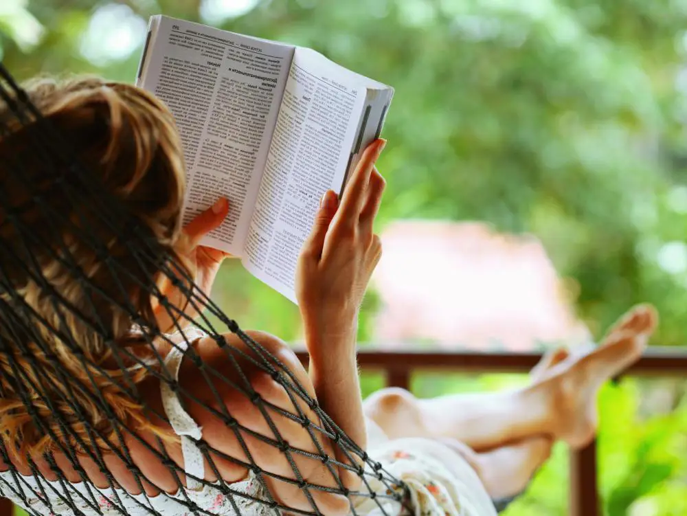 Seseorang bersantai sambil membaca buku