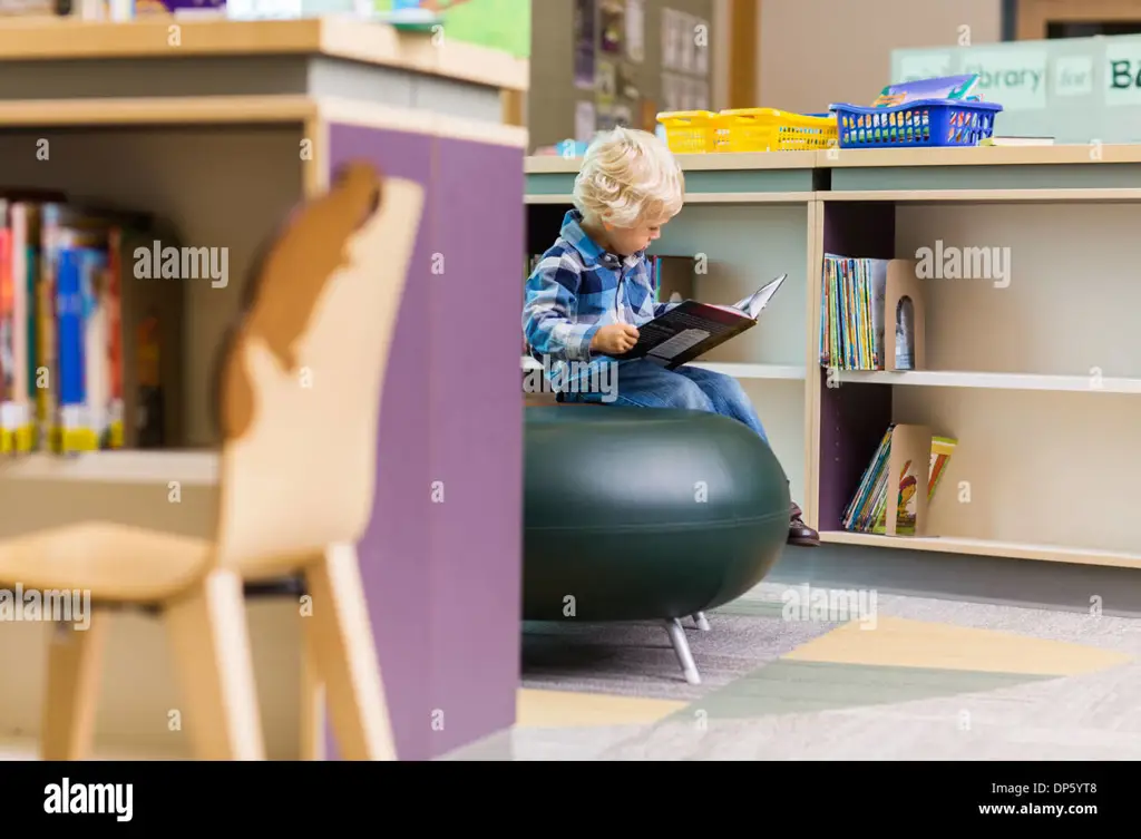 Seorang anak muda membaca buku di perpustakaan