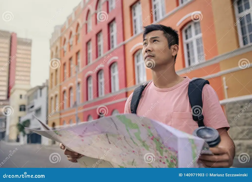 Seorang anak muda sedang menjelajahi jalanan kota yang penuh dengan gedung-gedung tinggi