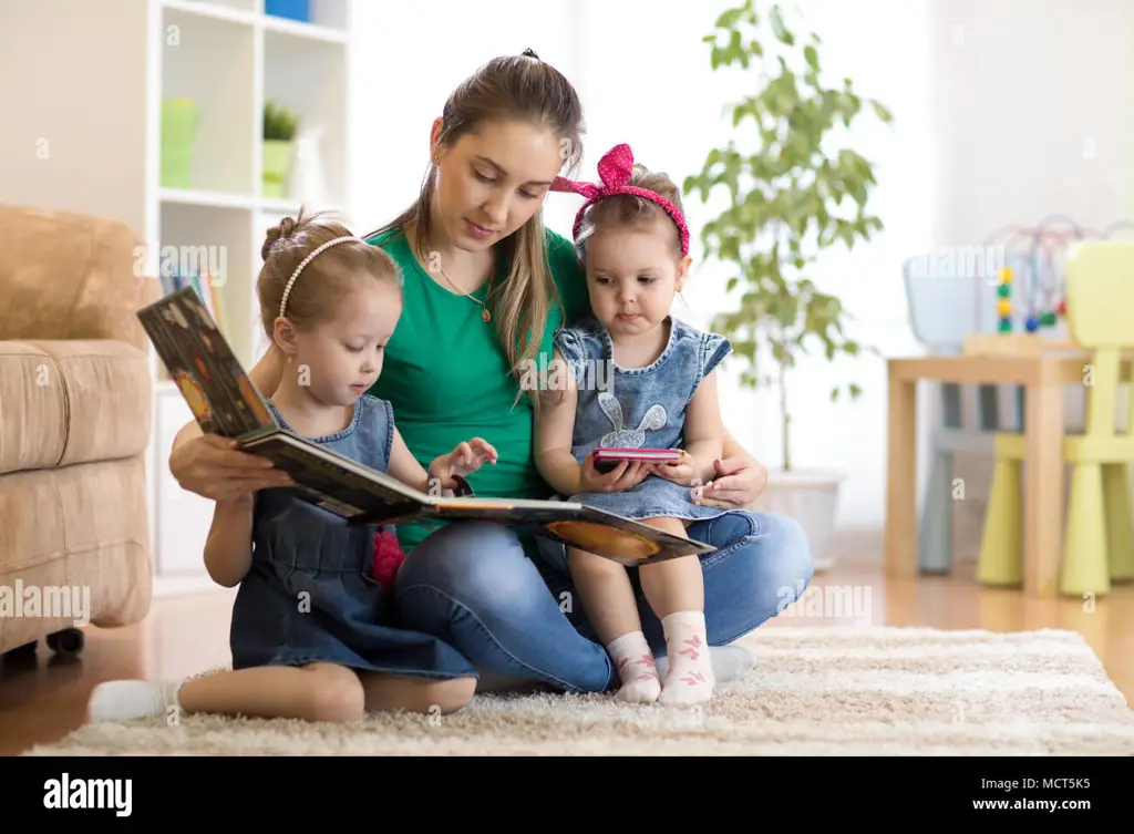 Ibu muda membaca buku untuk anaknya