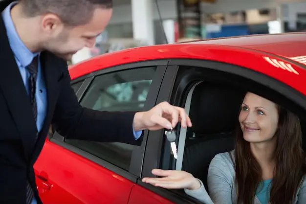 Gambar pelanggan bahagia menerima kunci mobil dari perwakilan Bussan Auto Finance