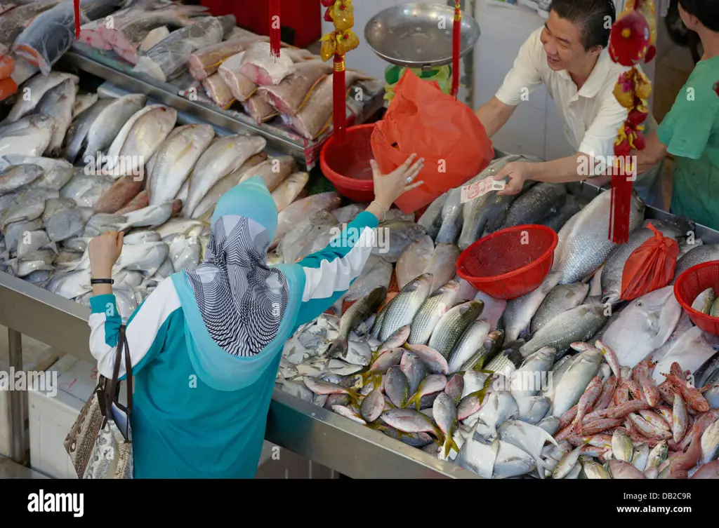 Seorang wanita membeli ikan asin di pasar