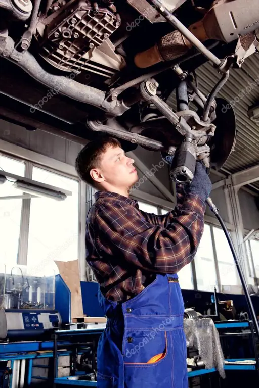 Mekanik memeriksa kondisi mobil bekas