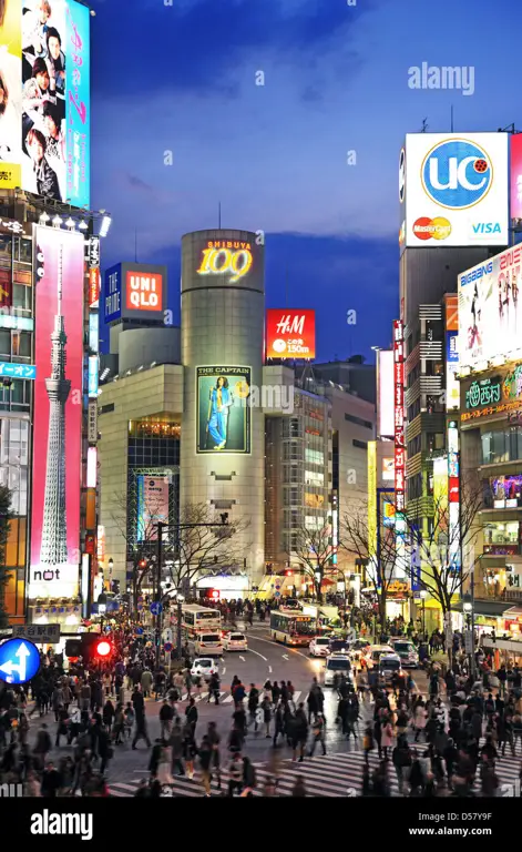 Foto Shibuya Crossing di malam hari, ramai dengan orang-orang yang menyeberang jalan