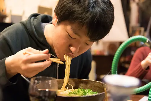 Orang-orang menikmati ramen bersama-sama