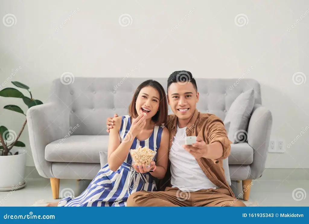 Pasangan sedang menonton televisi dengan bahagia