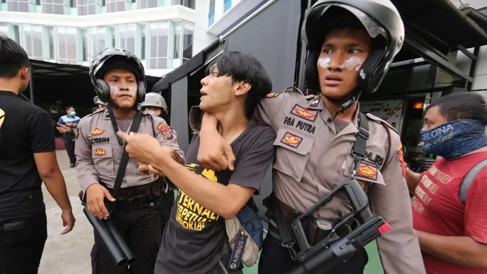 Petugas polisi Indonesia sedang bekerja di depan laptop.