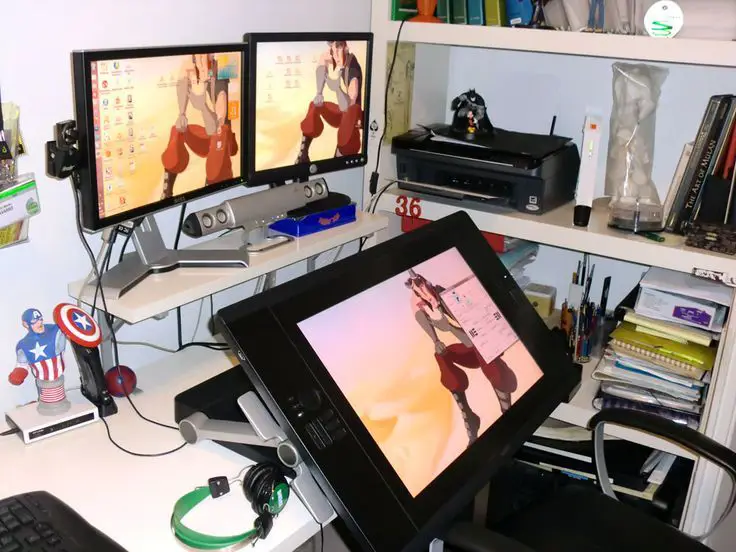 Gambar tempat kerja animator dengan komputer dan tablet